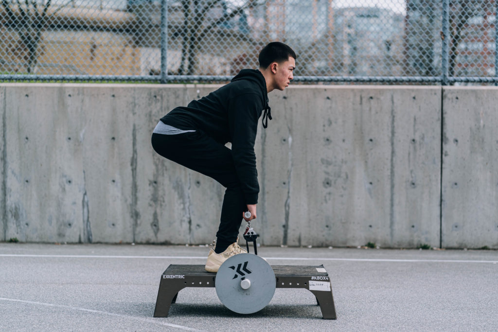 image of a YOUTH performing HIGH-PERFORMANCE TRAINING​ using flywheel training