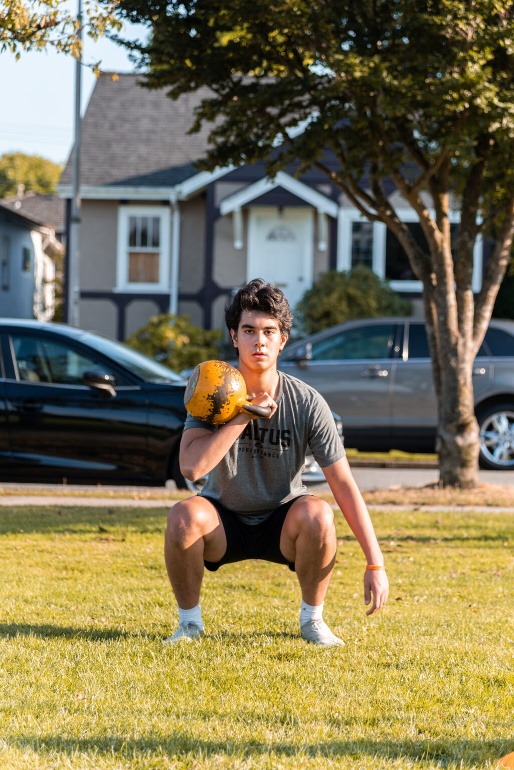Saltus Athlete squatting with a kettlebell in hand