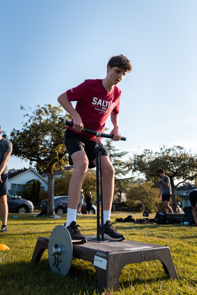 Saltus Athlete performing a flywheel training exercise outdoors