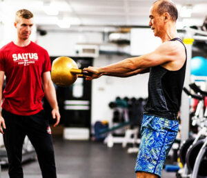 Sean coaching an adult on performance training at the Saltus Performance gym