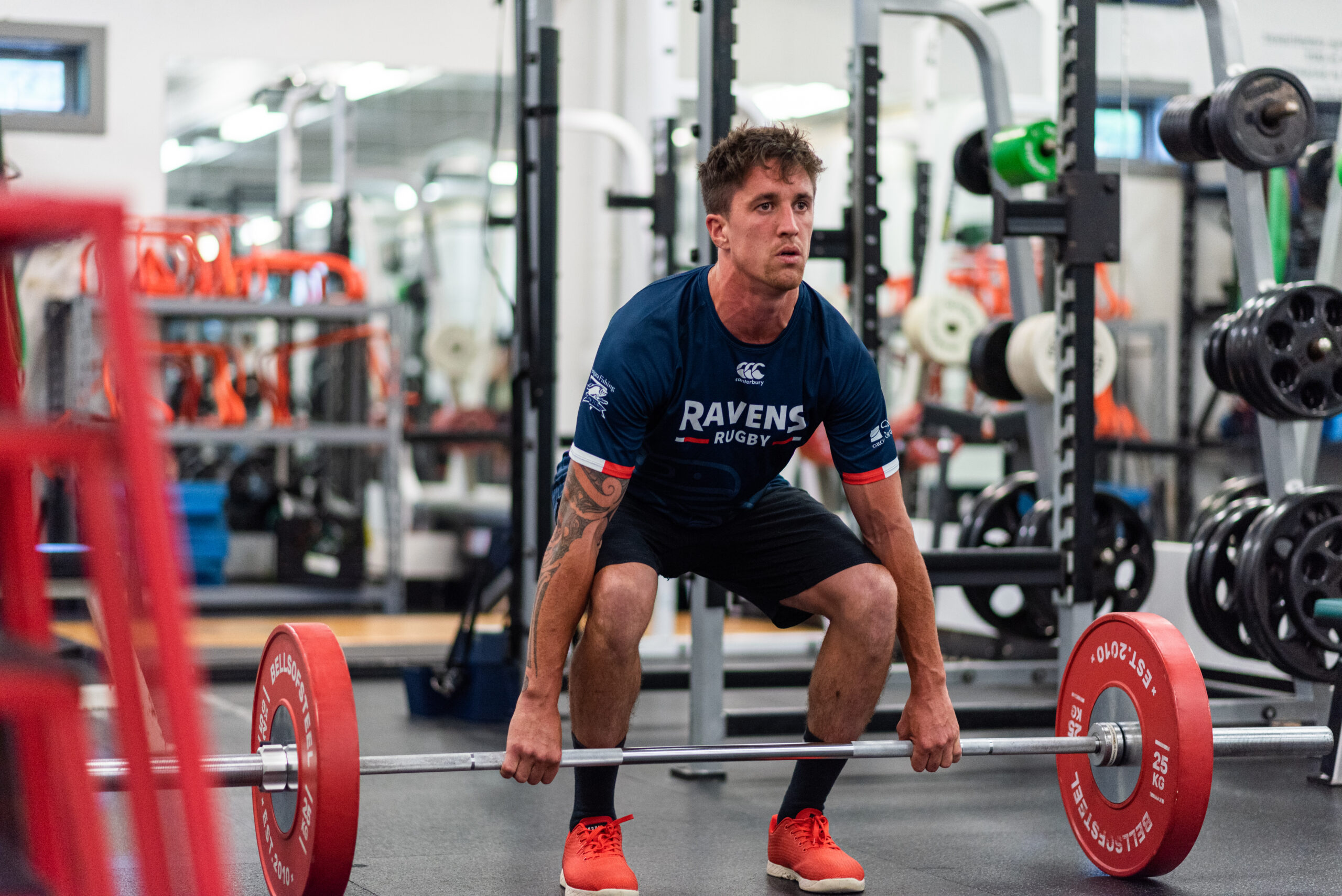 Image of a UBCOB Ravens rubgy player - Tom Kaijays performing a weight lift