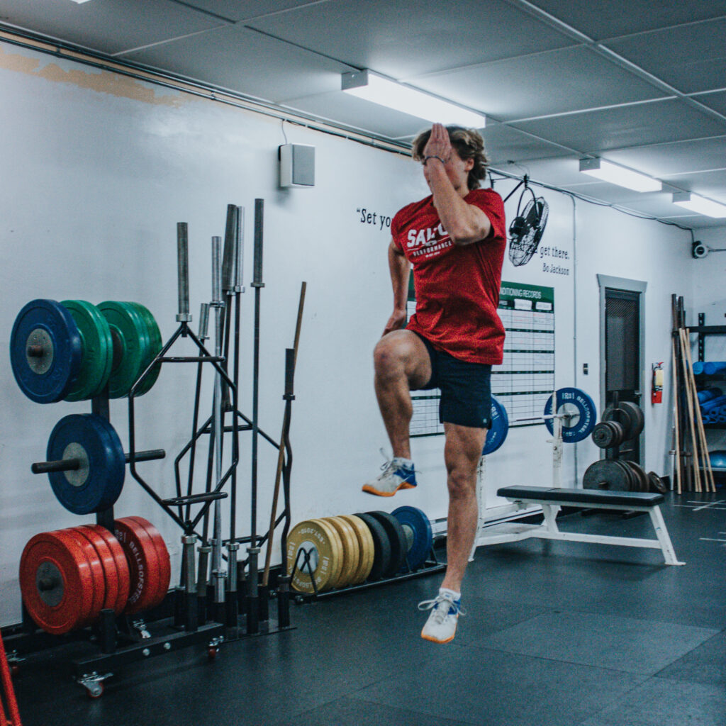 A man performing high knee sprints at the Saltus performance gym