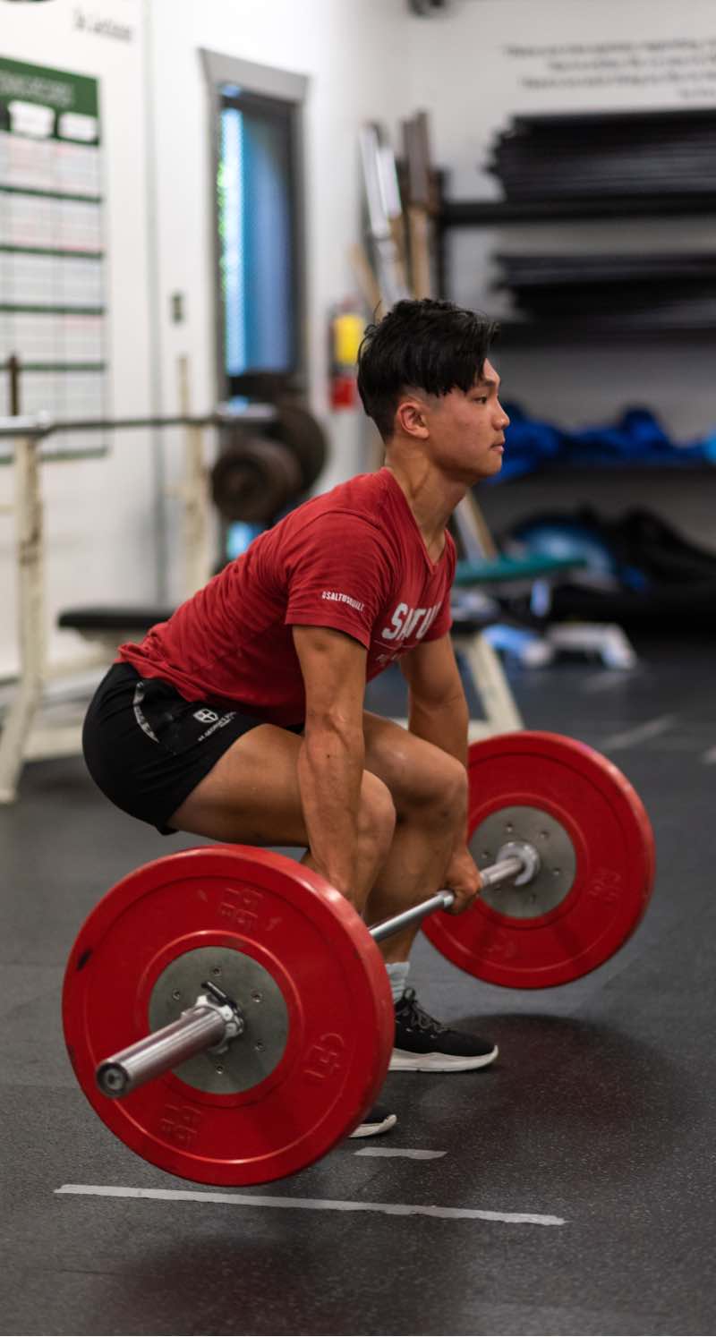 Photo of a man doing a deadlift in a saltus performance t-shirt