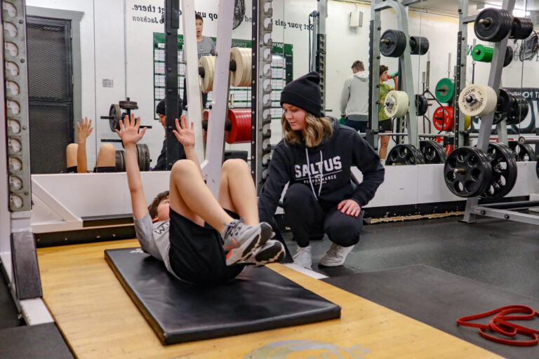 Image of a trainer working with a youth athlete at saltus performance